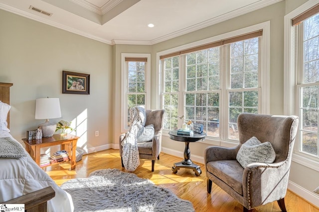 sitting room with ornamental molding, a tray ceiling, and light hardwood / wood-style floors