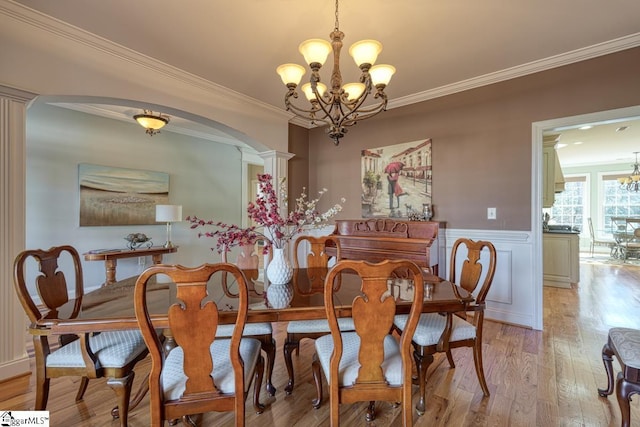 dining room featuring a notable chandelier, light hardwood / wood-style floors, and crown molding