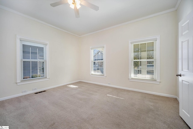 empty room with ornamental molding, light colored carpet, and ceiling fan