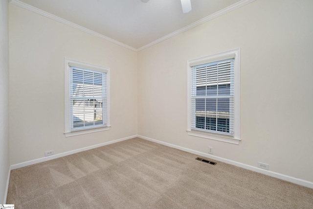 empty room featuring light colored carpet, ceiling fan, and crown molding