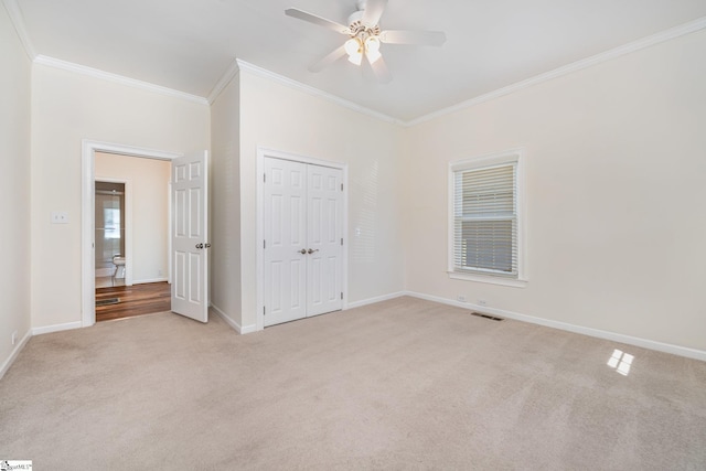 unfurnished bedroom with light carpet, a closet, ceiling fan, and ornamental molding