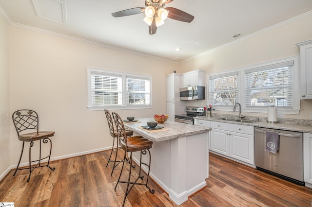 kitchen featuring a center island, dark hardwood / wood-style floors, stainless steel appliances, white cabinetry, and sink