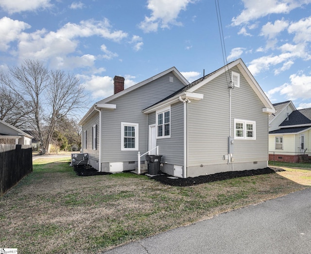 rear view of house featuring cooling unit and a lawn