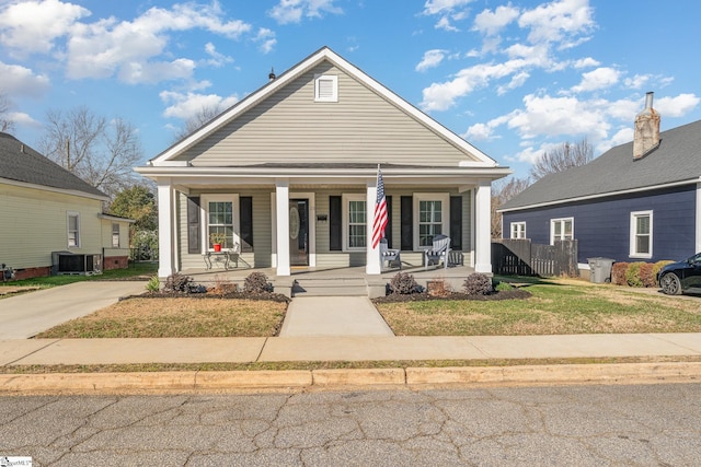 view of front of home featuring a porch, central air condition unit, and a front lawn