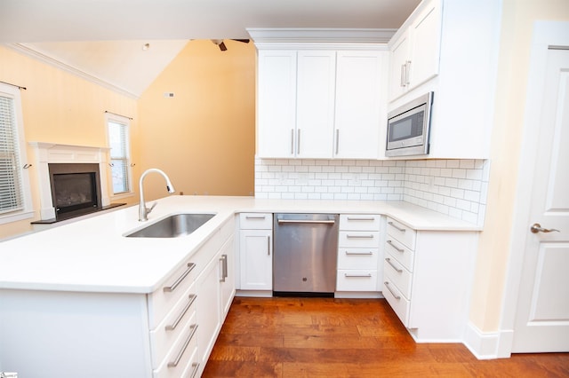 kitchen featuring sink, white cabinetry, kitchen peninsula, and appliances with stainless steel finishes