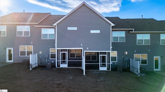 rear view of property with cooling unit and a sunroom