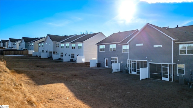 rear view of property with a lawn and a sunroom