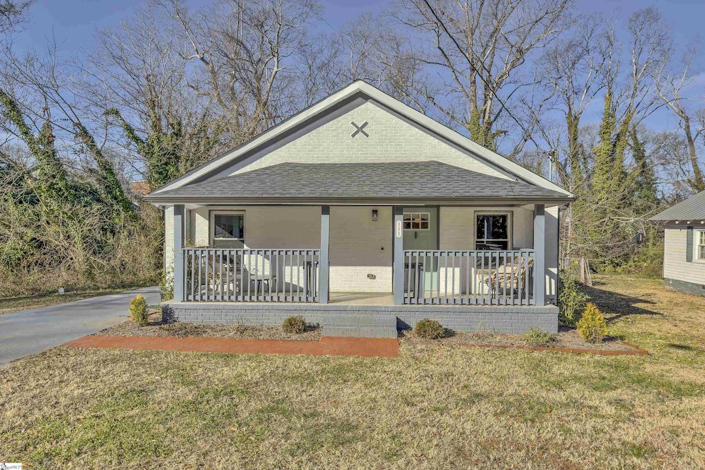 bungalow-style house with a front yard and covered porch