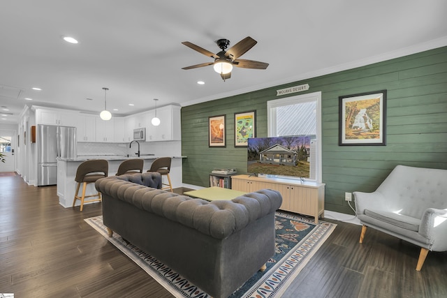 living room featuring sink, dark hardwood / wood-style flooring, ceiling fan, and crown molding