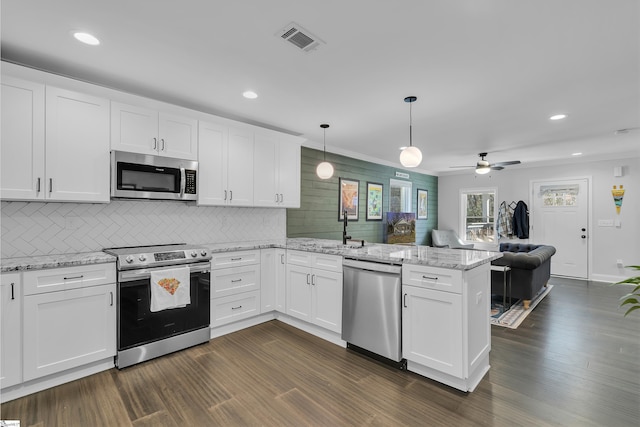 kitchen featuring kitchen peninsula, pendant lighting, stainless steel appliances, white cabinetry, and ceiling fan