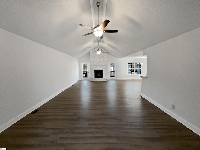 unfurnished living room with ceiling fan, dark wood-type flooring, vaulted ceiling, and a fireplace