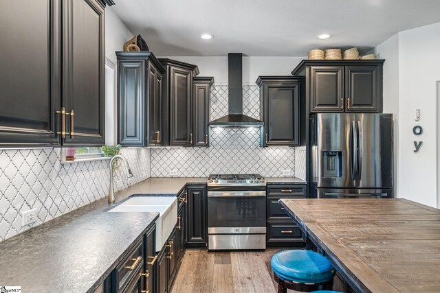 kitchen featuring sink, stainless steel appliances, wall chimney range hood, and tasteful backsplash