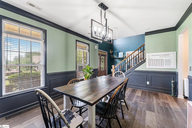 dining room with an inviting chandelier, ornamental molding, a wealth of natural light, and dark wood-type flooring