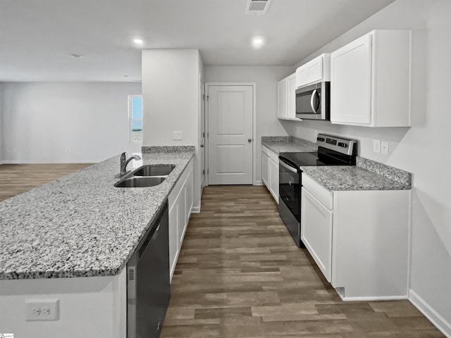 kitchen with kitchen peninsula, sink, light stone countertops, stainless steel appliances, and white cabinets