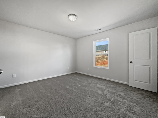 spare room featuring dark carpet