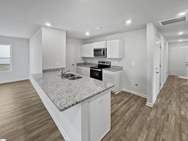 kitchen featuring a breakfast bar area, white cabinetry, kitchen peninsula, and black / electric stove