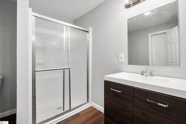 bathroom with wood-type flooring, walk in shower, and vanity