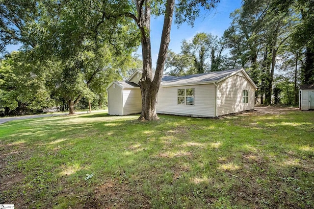 view of property exterior featuring a lawn and a storage shed