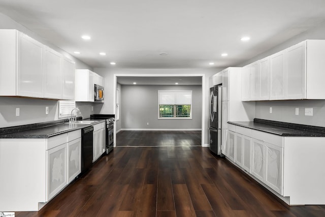 kitchen featuring white cabinets, appliances with stainless steel finishes, dark hardwood / wood-style flooring, and sink