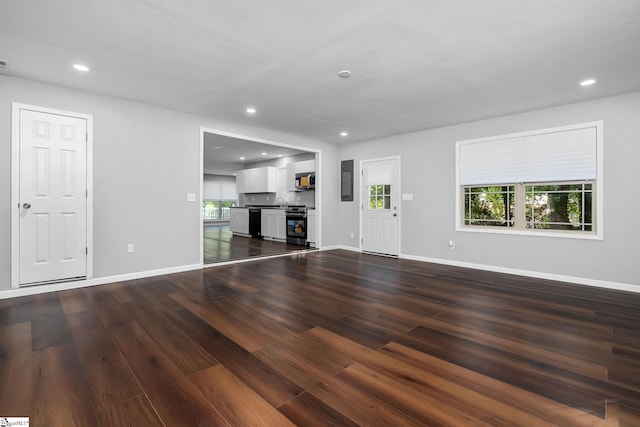 unfurnished living room with electric panel and dark hardwood / wood-style floors