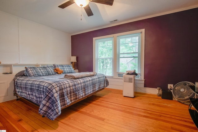 bedroom with ceiling fan, light hardwood / wood-style flooring, and crown molding