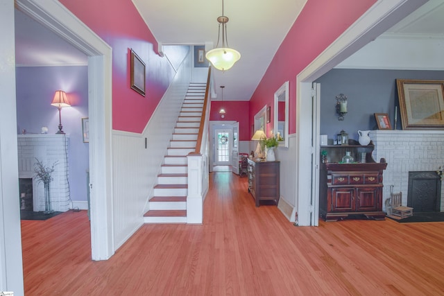 entryway featuring light hardwood / wood-style floors and a brick fireplace