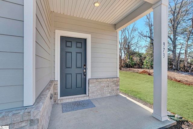 property entrance featuring a lawn