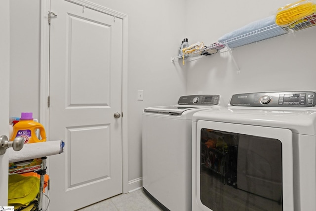 clothes washing area featuring light tile patterned flooring and independent washer and dryer