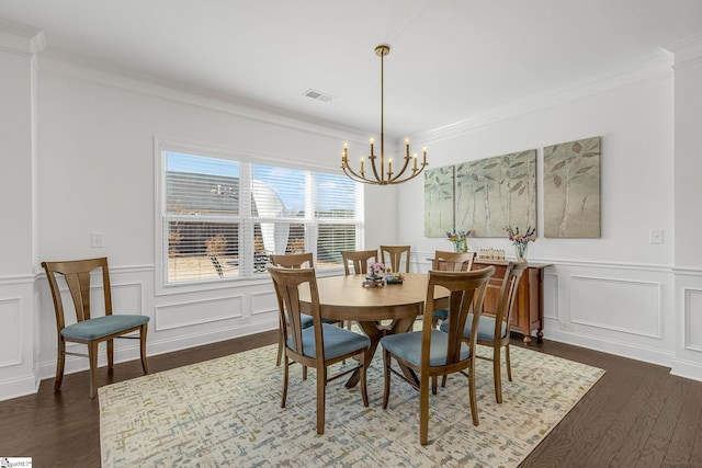 dining area with dark hardwood / wood-style floors, crown molding, and a chandelier