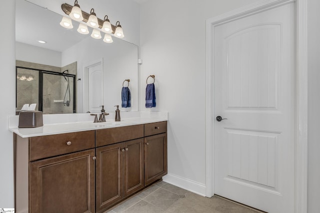 bathroom featuring tile patterned flooring, a shower with shower door, and vanity