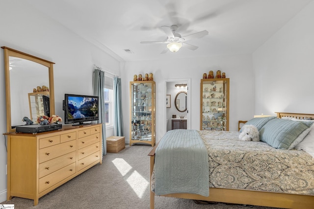 bedroom featuring ensuite bathroom, light carpet, and ceiling fan