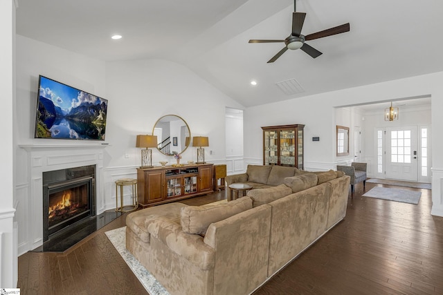 living room featuring ceiling fan with notable chandelier, vaulted ceiling, and dark hardwood / wood-style floors