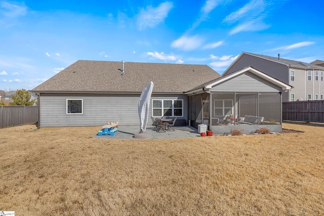 rear view of property with a patio, a yard, and a sunroom