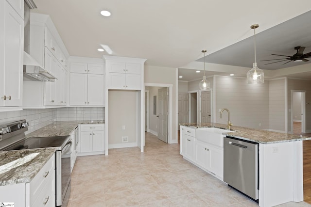 kitchen featuring decorative light fixtures, white cabinets, a center island with sink, and appliances with stainless steel finishes