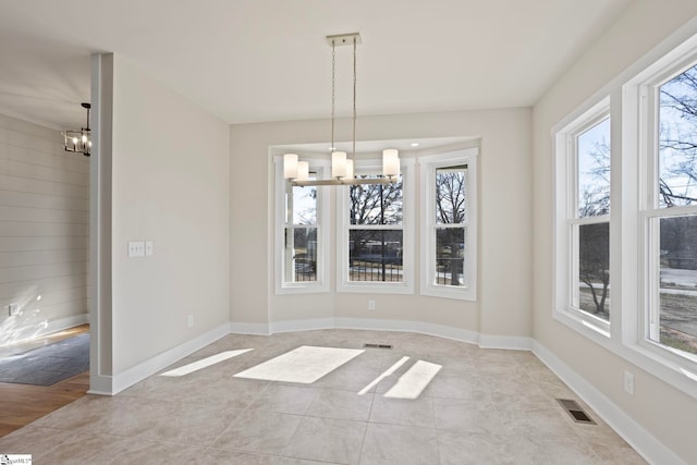 unfurnished dining area featuring a notable chandelier and light tile patterned floors