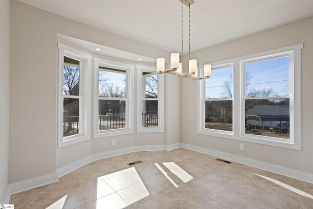 unfurnished dining area featuring a healthy amount of sunlight, an inviting chandelier, and light tile patterned floors