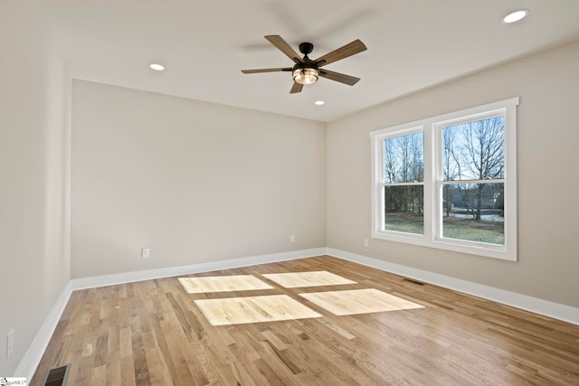 empty room with ceiling fan and light hardwood / wood-style flooring