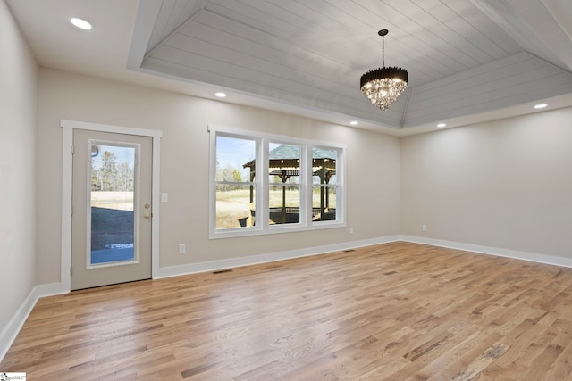 spare room with light hardwood / wood-style floors, wooden ceiling, an inviting chandelier, and a tray ceiling