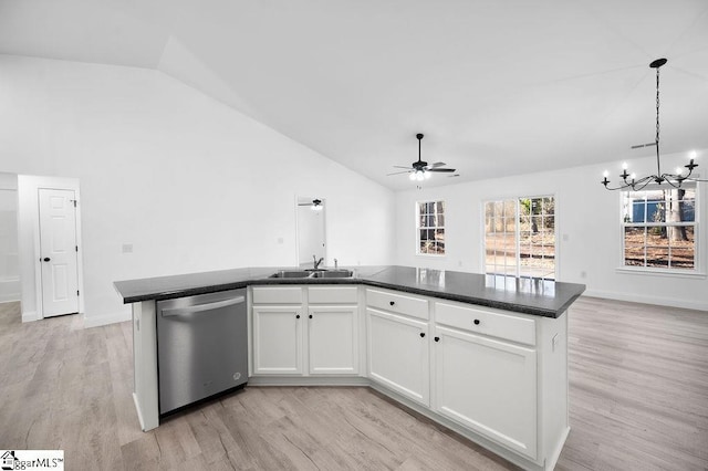 kitchen with white cabinets, vaulted ceiling, dishwasher, an island with sink, and ceiling fan with notable chandelier