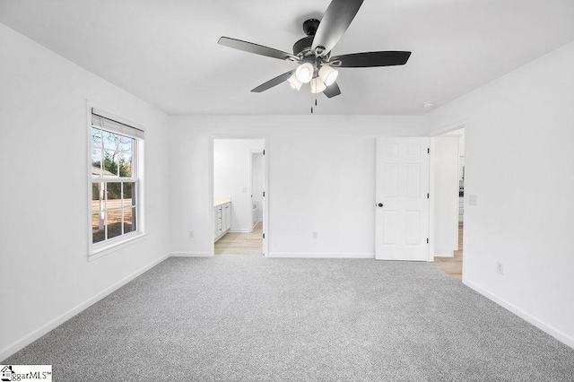 unfurnished bedroom with ensuite bath, light colored carpet, and ceiling fan