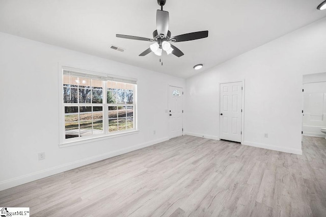 spare room featuring ceiling fan, light wood-type flooring, and vaulted ceiling