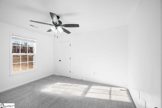 carpeted spare room featuring ceiling fan