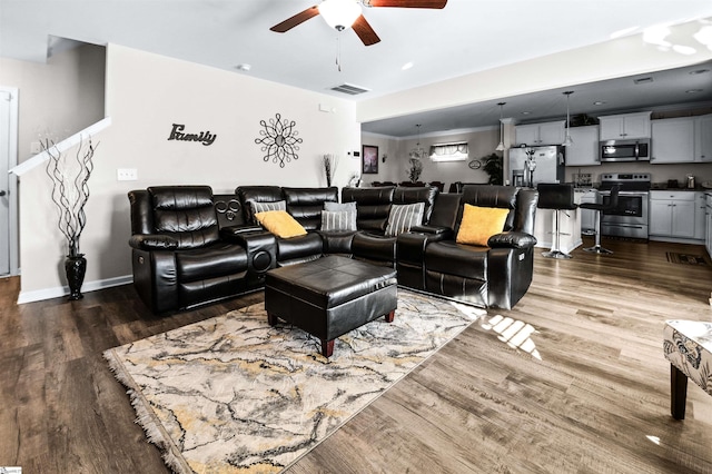 living room with ceiling fan and dark hardwood / wood-style floors