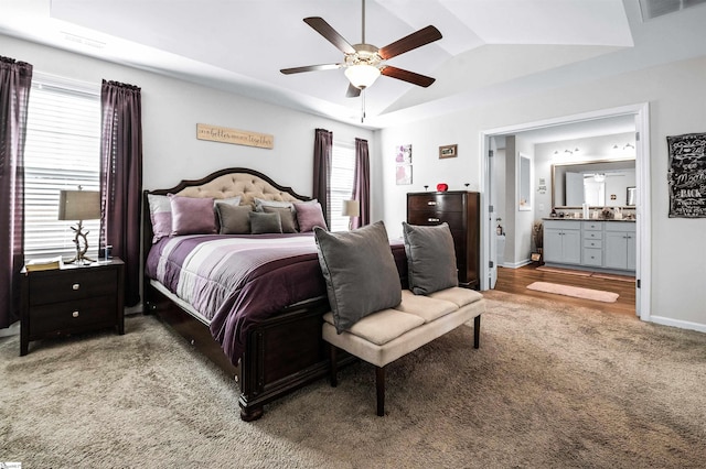 carpeted bedroom featuring lofted ceiling, connected bathroom, multiple windows, and ceiling fan