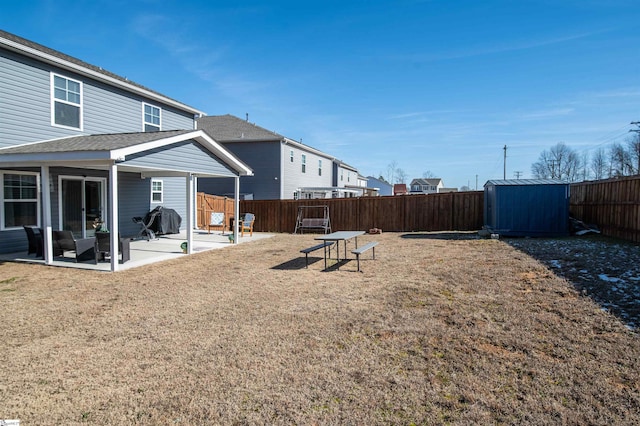 view of yard featuring a storage unit and a patio