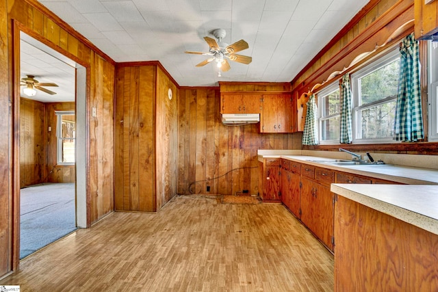 kitchen with a healthy amount of sunlight, under cabinet range hood, light countertops, and brown cabinetry