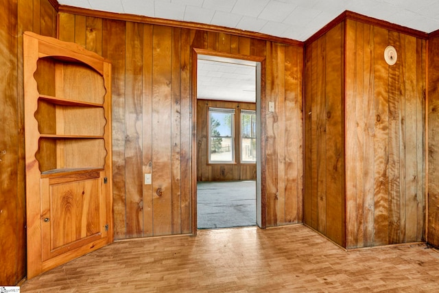 empty room featuring light wood-style flooring and wooden walls