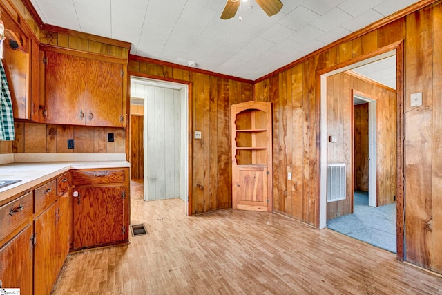 kitchen featuring visible vents, brown cabinetry, a ceiling fan, light countertops, and light wood-type flooring