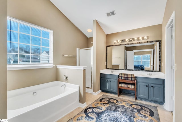 bathroom featuring independent shower and bath, vanity, tile patterned flooring, and vaulted ceiling