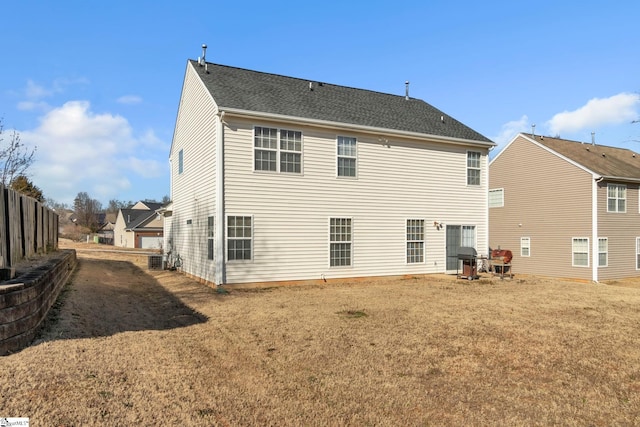 rear view of property with a yard and central AC